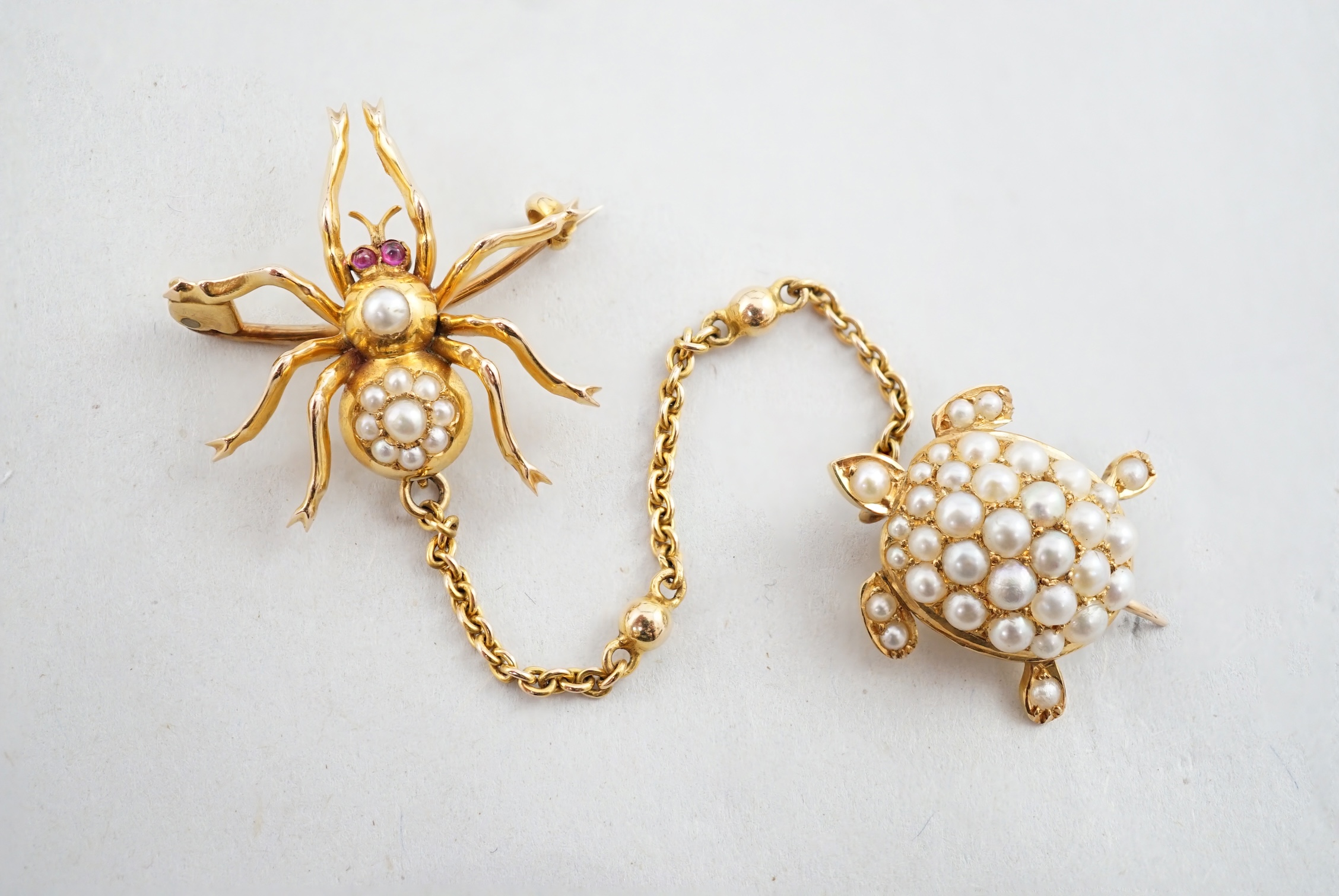 A late Victorian gold and seed pearl set brooch with suspension chain and clip, modelled as a spider with turtle